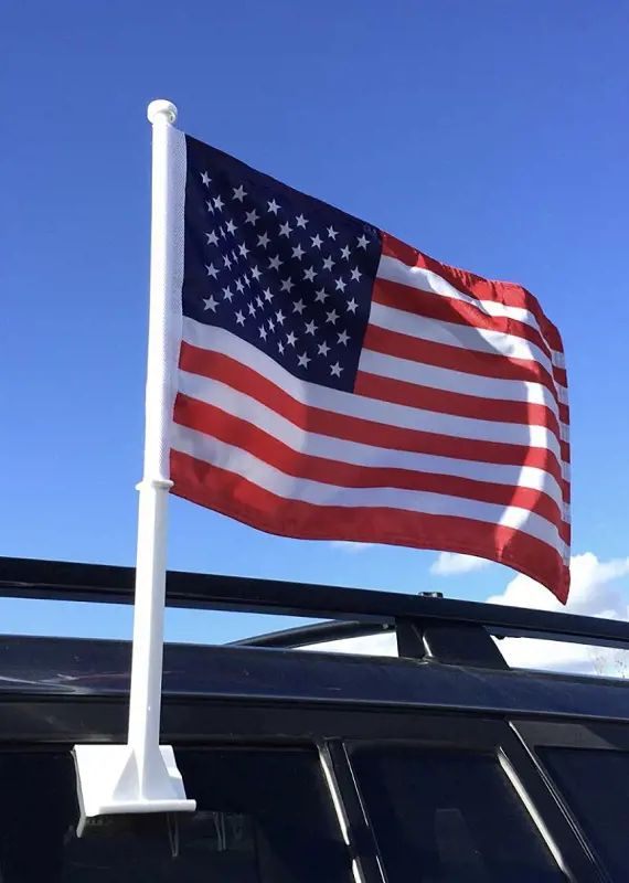 The United States Flag flying on the side of a black vehicle. 