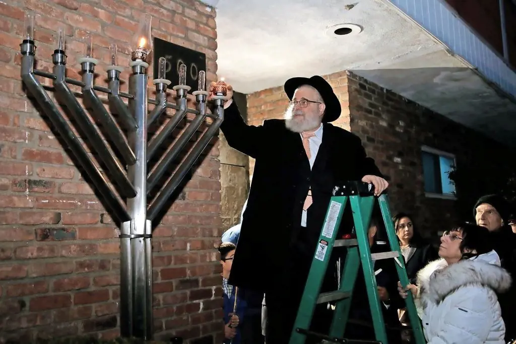 Rabbi Chaim Blachman lights up the menorah at the Elmont Jewish Center
