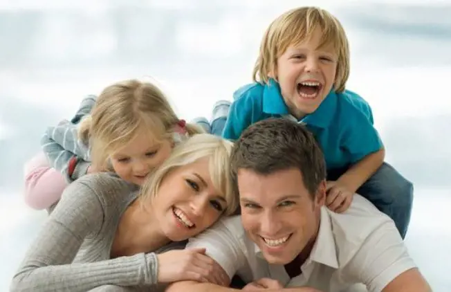 Family of four spending quality time with wide smile in their face