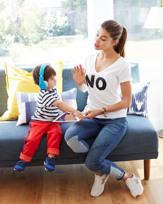 A mother talks to her toddler about the tablet usage time limit carefully to not provoke a tantrum. 