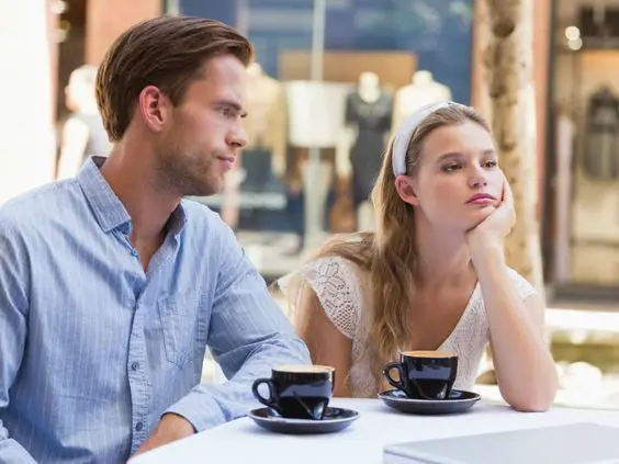 An Image showing a unhappy couple at a cafe 