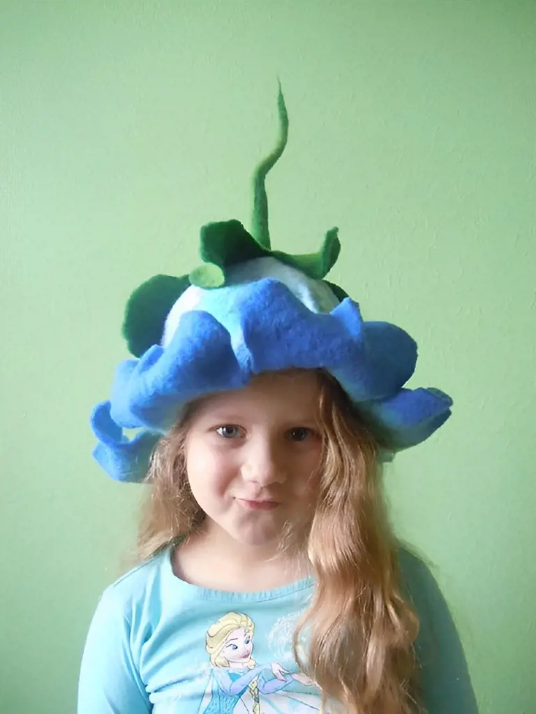 A precious girl adorns a hat with a delightful bluebell flower design