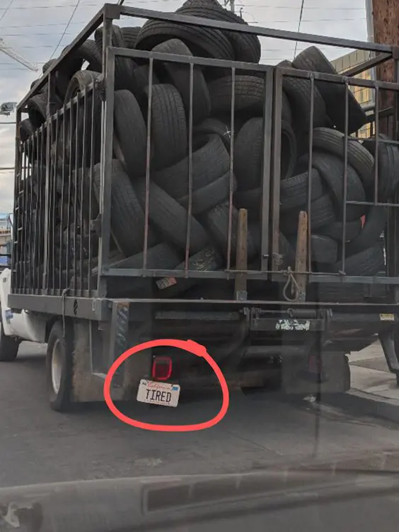 A truck full of tires with a funny license plate